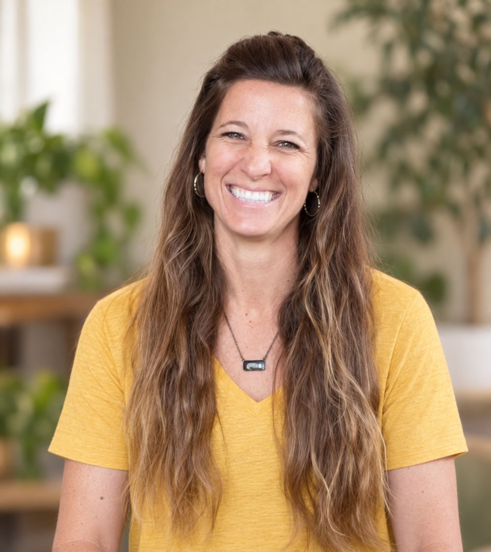 Heidi Krumreich, intuitive guide and relationship coach, smiling in a plant-filled room